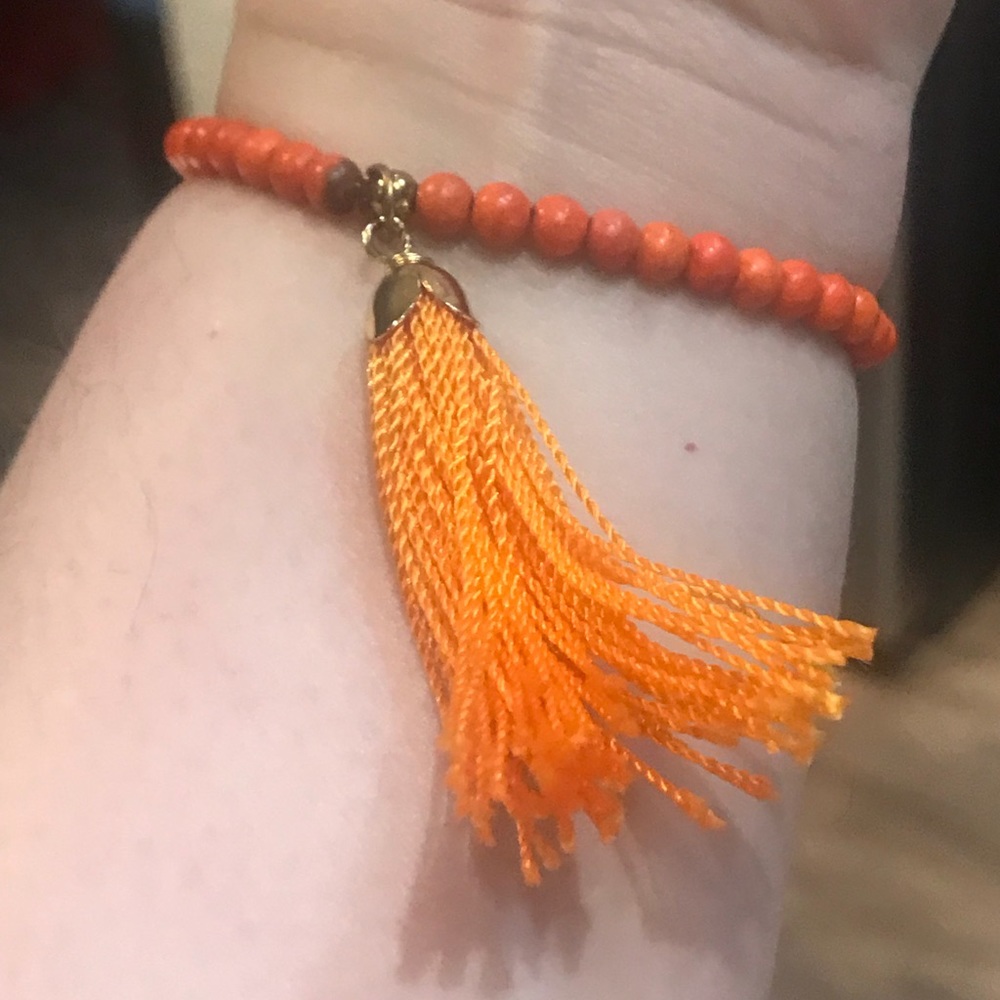 Orange beaded bracelet with tassel